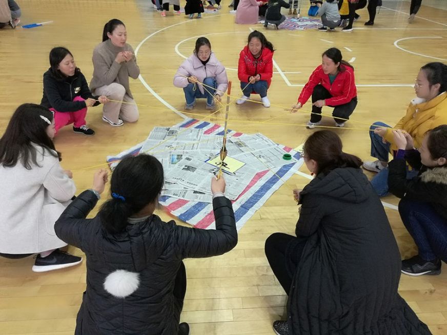 四公司女工委组织开展韶关片区女职工素质拓展活动。图为队员共同用一支笔在纸上写下团队的口号。 杨婷 摄<br />