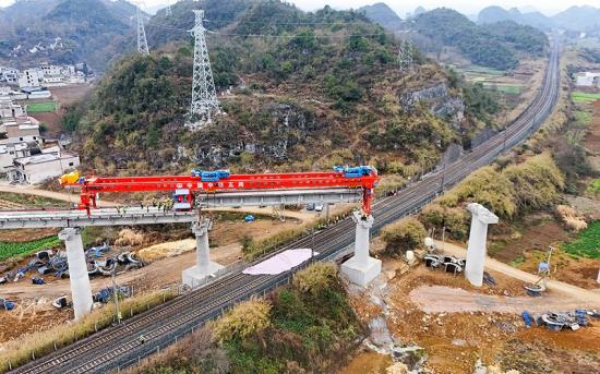 2月13日,随着长32米重135吨的T梁稳稳落在下行联络线斗篷山特大桥30至31号桥墩间,安六铁路客车联络线成功上跨既有沪昆铁路。该联络线新建线路全长约5.7公里,其中上行联络线长约3.2公里,下行联络线长约2.5公里。项目部与铁路运营部门密切配合争分夺秒开展施工,经过全体施工人员的不懈努力,成功上跨既有沪昆铁路。目前,架设工作已完成76%。 杨树良王鹏摄影报道 2月13日,随着长32米重135吨的T梁稳稳落在下行联络线斗篷山特大桥30至31号桥墩间,安六铁路客车联络线成功上跨既有沪昆铁路。该联络线新建线路全长约5.7公里,其中上行联络线长约3.2公里,下行联络线长约2.5公里。项目部与铁路运营部门密切配合争分夺秒开展施工,经过全体施工人员的不懈努力,成功上跨既有沪昆铁路。目前,架设工作已完成76%。 杨树良王鹏摄影报道